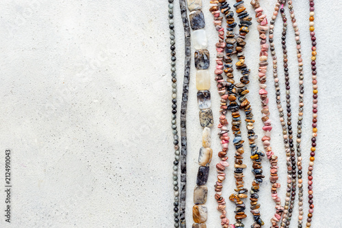 Precious and jewelry flat lay background. Lots of gemstones for necklace and bracelets, top view