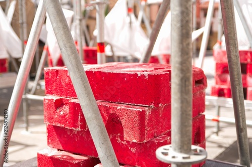 Canvas Print Red concrete counterweight blocks used as ballast for temporary scaffolding cons