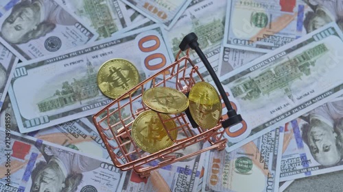 Gold bitcoin coins drop into mini shopping cart over US dollar bills for crypto purchases and commerce concept