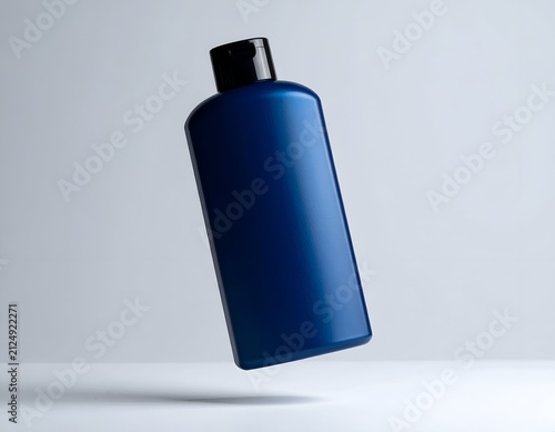A sleek, dark blue cylindrical bottle with a black cap, seemingly floating against a gray backdrop