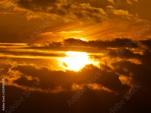 Fotografie Golden sky sunset hiding behind dark clouds