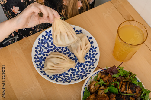 Delicious and appetizing homemade khinkali with meat filling floating in broth