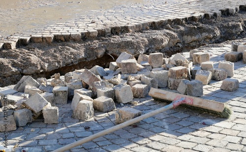 Baustelle mit Pflastersteinen und Besen, Straßenerneuerung