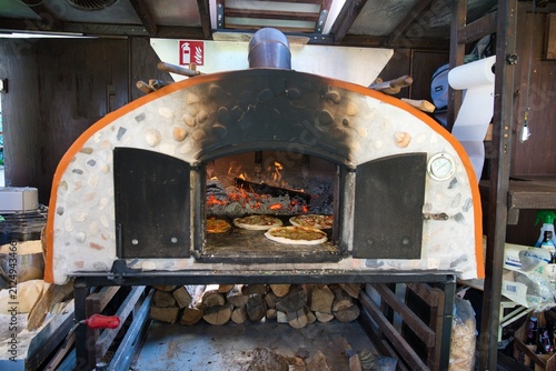 Fresh pizzas baking inside a traditional wood fired stone oven.