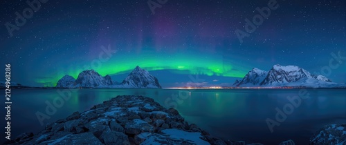 Northern Lights Illuminating Snowy Mountains Over Calm Water at Night