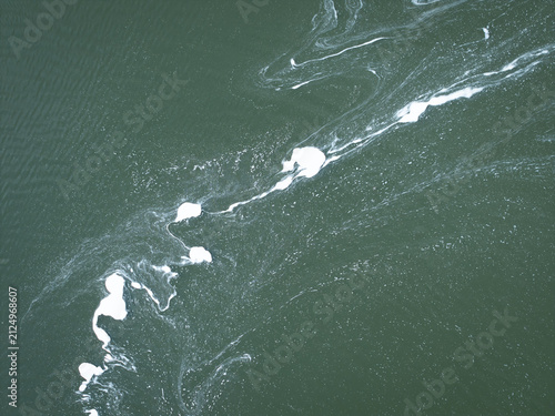Aerial view of colorful water and white foam patterns in the sugar refinery settling ponds, Poland.
