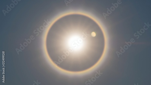 Sun Halo Around Bright Sun with a Small Celestial Body in Clear Sky