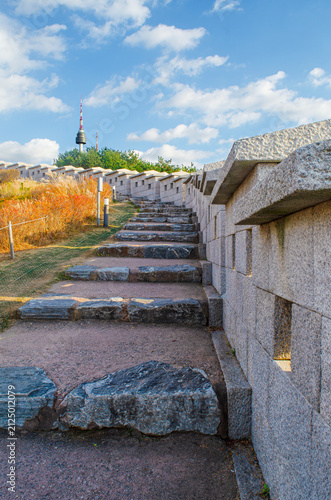 The stone steps along the old Seoul City Wall leading up to N Seoul Toewr. SEOUL SOUTH KOREA - November 22, 2025: Seoul Tower on sky background .