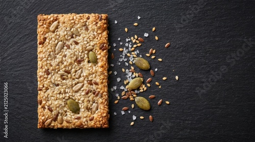Healthy Whole Grain Cracker with Seeds on Dark Slate Background.