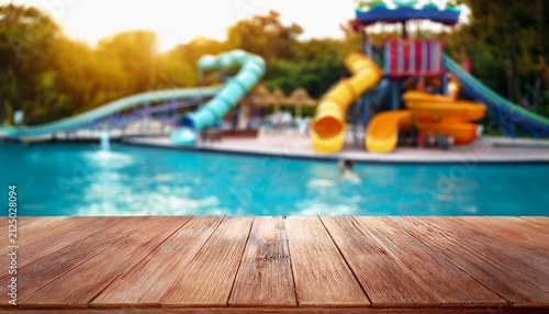 the empty wooden table top with blur background of water park for product display