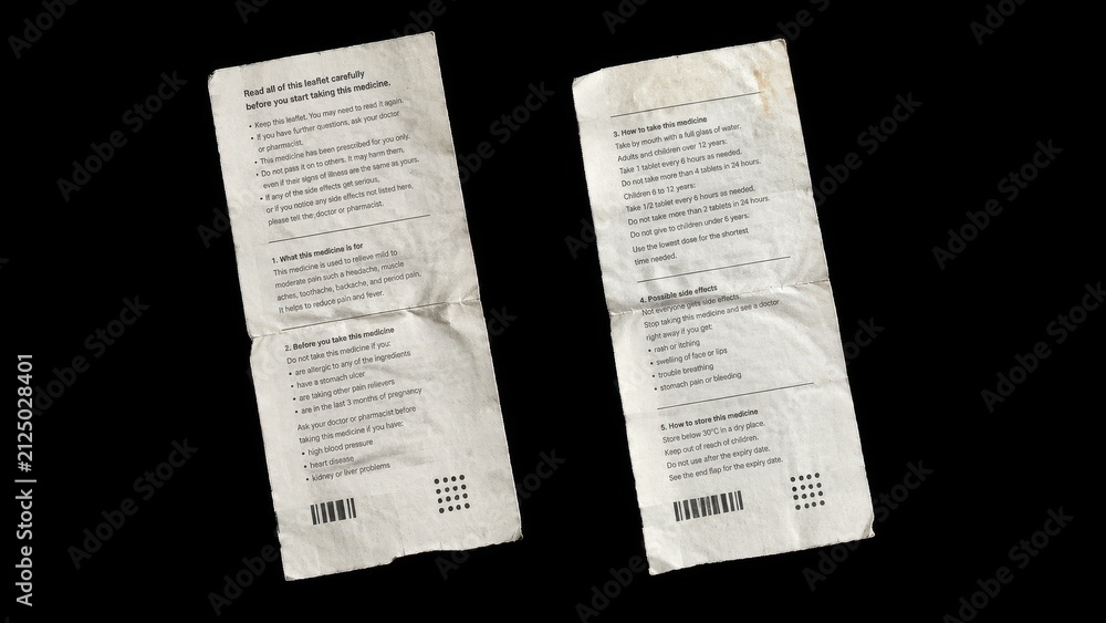 Fototapeta premium Two folded medicine instruction leaflets isolated on black