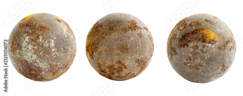 Three weathered cannonballs with rust and patina textures