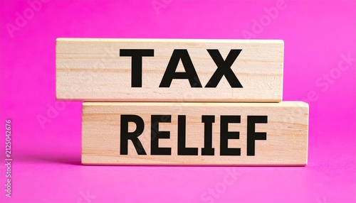 Two wooden blocks stacked vertically against bright pink background, top block printed with bold black letters “TAX,” bottom block printed with bold black letters “RELIEF,” minimalist composition visu