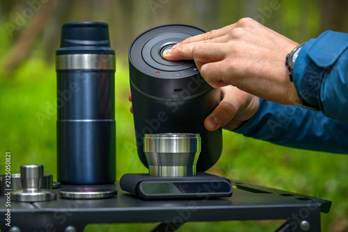Hand operating vacuum coffee canister to preserve fresh coffee beans during outdoor brewing