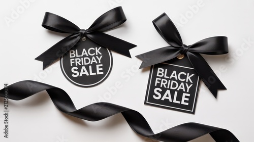 Black Friday Black Friday sale price tags with elegant black satin ribbons floating against a bright white background for premium commercial use