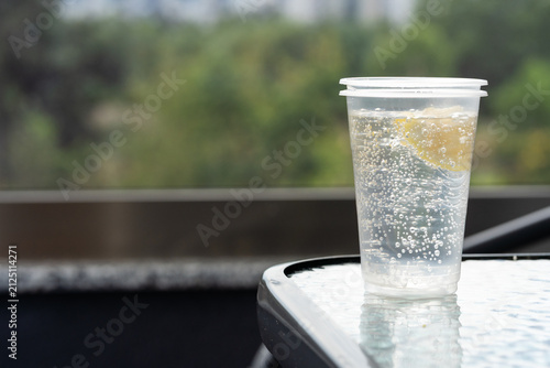 Konstfotografi Close-up of a sparkling carbonated drink with a lemon slice in a clear plastic c