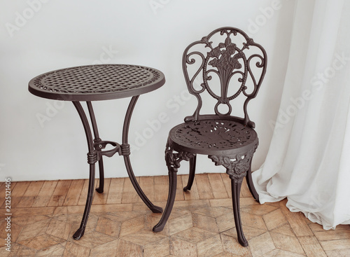 Vintage wrought iron chair and table in the room