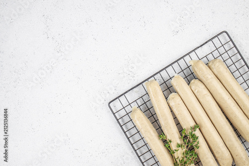 Принти на полотні Freshly prepared sausages arranged on a wire cooling rack with sprigs of thyme o