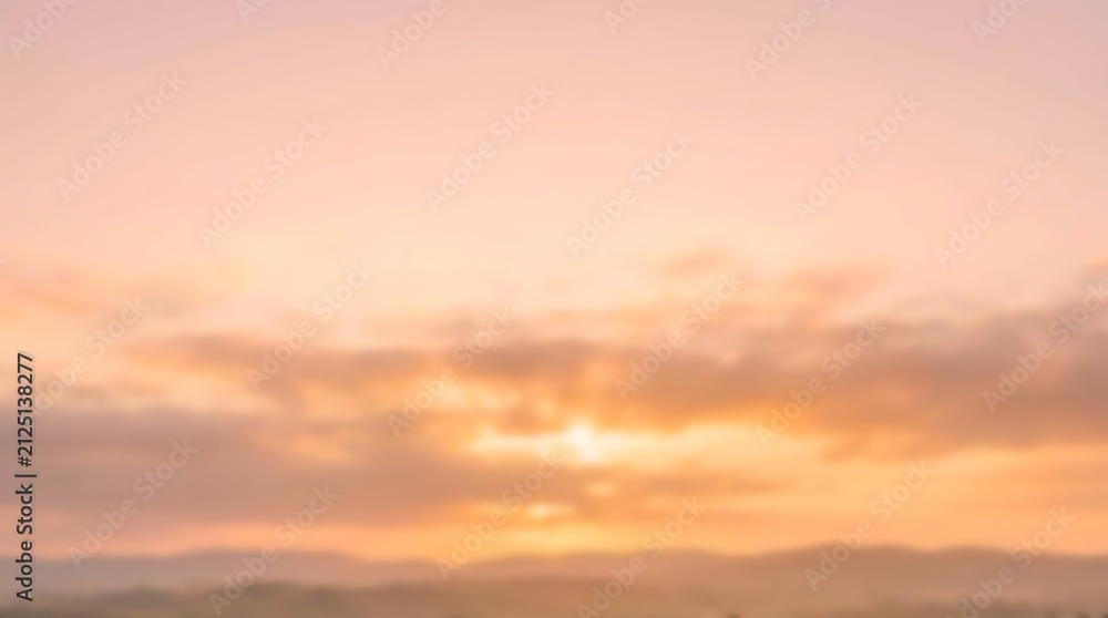 Fototapeta premium A breathtaking sunrise paints the sky with soft pink, orange, and yellow hues over a serene, misty landscape of rolling hills.