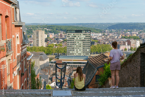 Visitors admire a panoramic city view from a scenic hillside viewpoint in Liege - famous Montagne de Bueren