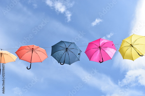Colorful hanging umbrellas against a bright blue sky