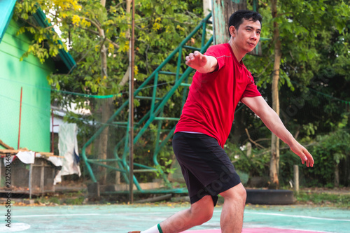 Fotografie Male Sepak takraw player stands in a athletic defensive stance, concentrating in