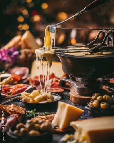 Melting cheese dip fondue with meat and olive snacks