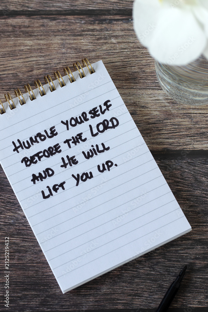 Obraz premium Christian quote for humility in a notebook on a wooden background. Biblical concept of repentance, obedience, and faith in God Jesus Christ.