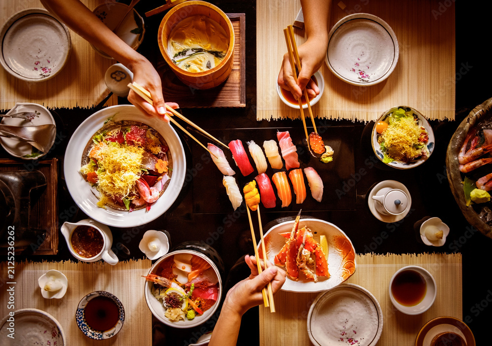 Obraz premium Top view sushi dinner with chopsticks and Japanese dishes
