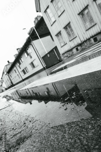 Monochrome reflection of wooden houses in puddle