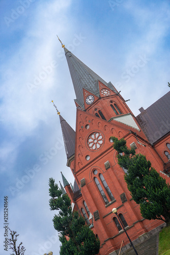 Red brick church tower under cloudy sky