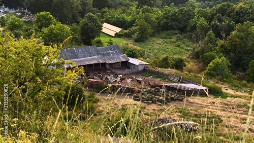 Fotografie An aerial view of a traditional sheepfold and farmyard in the scenic rural hills of Iasi, Romania