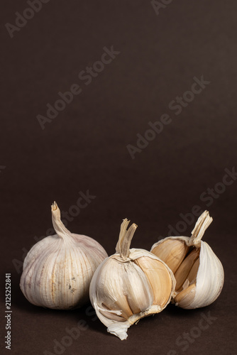 Whole and Split Garlic Bulbs on Brown Background
