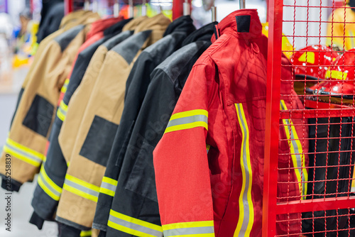 Firefighter protective suits hanging clothes on rail fireman safety uniforms prepared emergency rescue station, Firefighter uniforms Firefighting suits for firefighters. Fireproof clothing,