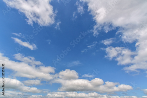 Cloudscape with white fluffy clouds in sunset sky