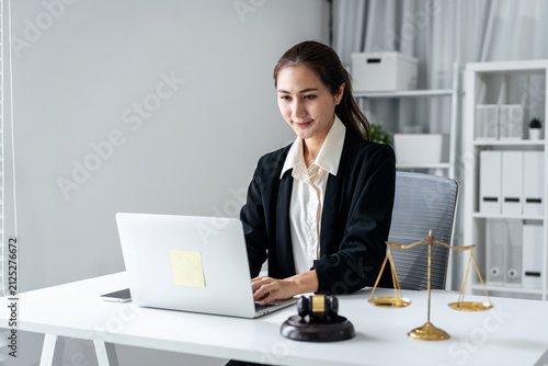 Legal professional woman works laptop office desk justice scales gavel law firm attorney consultation business administration professional environment