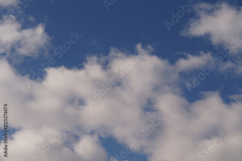 Cloudscape with white fluffy clouds in sunset sky