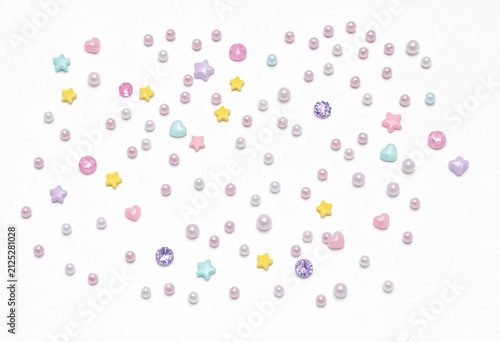 Pastel Beads and Stars Scattered on White Background