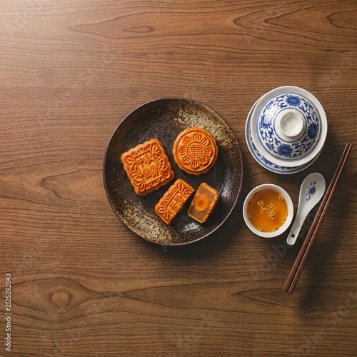 Aesthetic Mid-Autumn Festival Food Photography with Traditional Mooncakes and Tea Service on Rustic Wood.