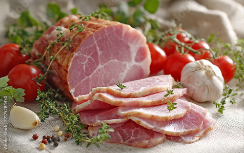 Sliced ​​ham is arranged on a table, surrounded by fresh herbs; white marbling is clearly visible on the meat slices, with tomatoes nearby and garlic in front. The illustration is rendered in t