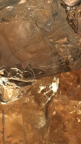 Cinematic macro shot of rich amber whiskey liquid with glowing reflections, deep golden tones and elegant fluid textures. A luxurious spirit atmosphere evoking aged whiskey craftsmanship. 
