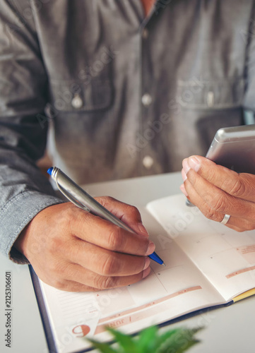 Calendar reminder event concept.Man hand planner or organizer writing in diary and 2026 Calendar page.Student holding smartphone and planning appointment.Male noted and count Down schedule day in book