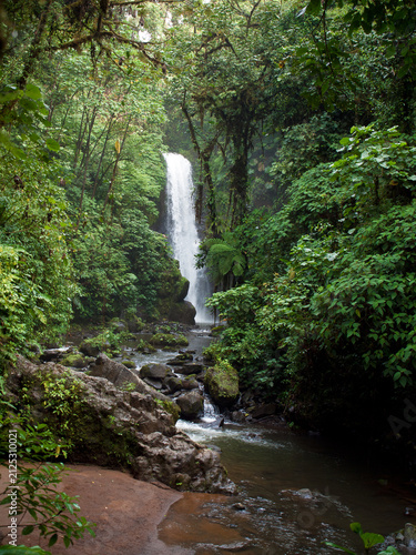 Canvas Print A lush tropical waterfall surrounded by dense rainforest in La Paz Waterfall Gardens near San José, Costa Rica