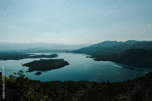 Фотография Wide panoramic landscape of Slano Lake with forested islands and distant mountain ranges in Montenegro