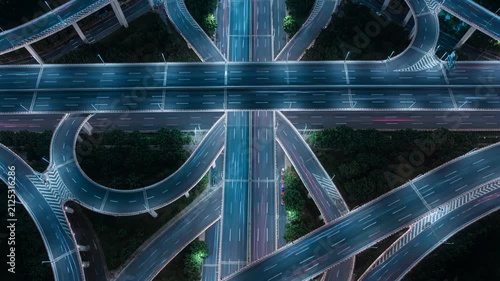 Aerial view of a complex highway junction and city interchange at night featuring glowing road lights and infrastructure connectivity