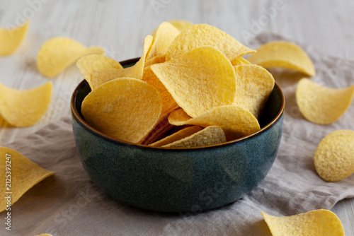 Crunchy Sour Cream and Onion Flavoured Potato Chips in a Bowl, side view. Close-up.