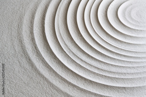 Abstract texture with concentric circles in zen sand garden style, gray
