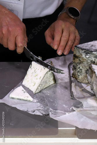 chef cortando un trozo de queso azul cremoso