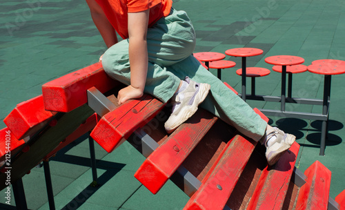 Close-up of child climbing on red wooden ladder on playground. Active outdoor games and physical development for children.