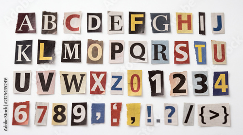 A collection of individual letters, numbers, and punctuation marks cut from various newspapers on a white background.